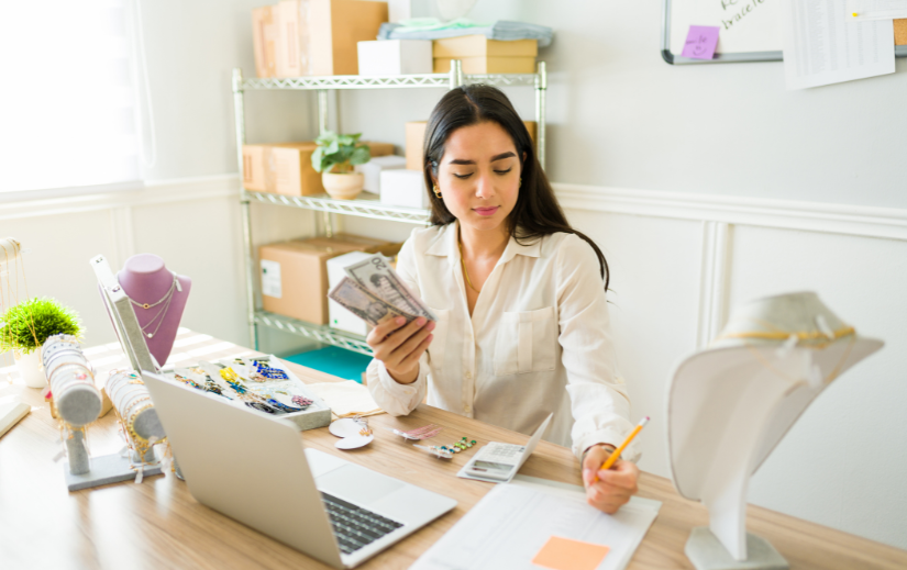 Entrepreneur managing an online jewelry business, counting cash and organizing inventory—ideal for profitable eBay strategy.